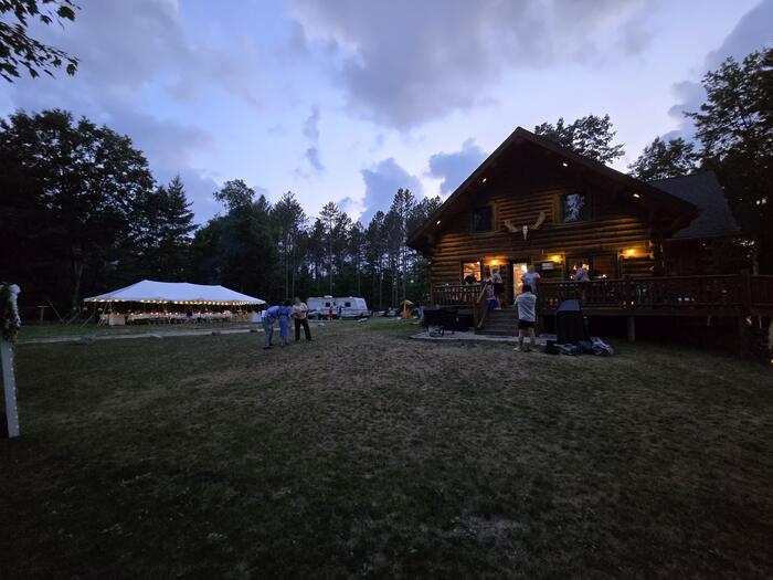 The reception tent glows into the evening, wedding at Edgetts Lodge, Luther Michigan