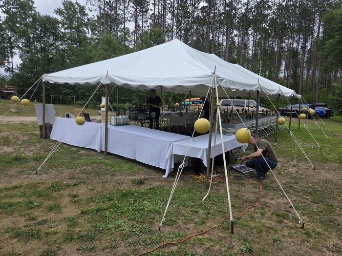 The tent goes up on the lower lawn, wedding at Edgetts Lodge, Luther Michigan