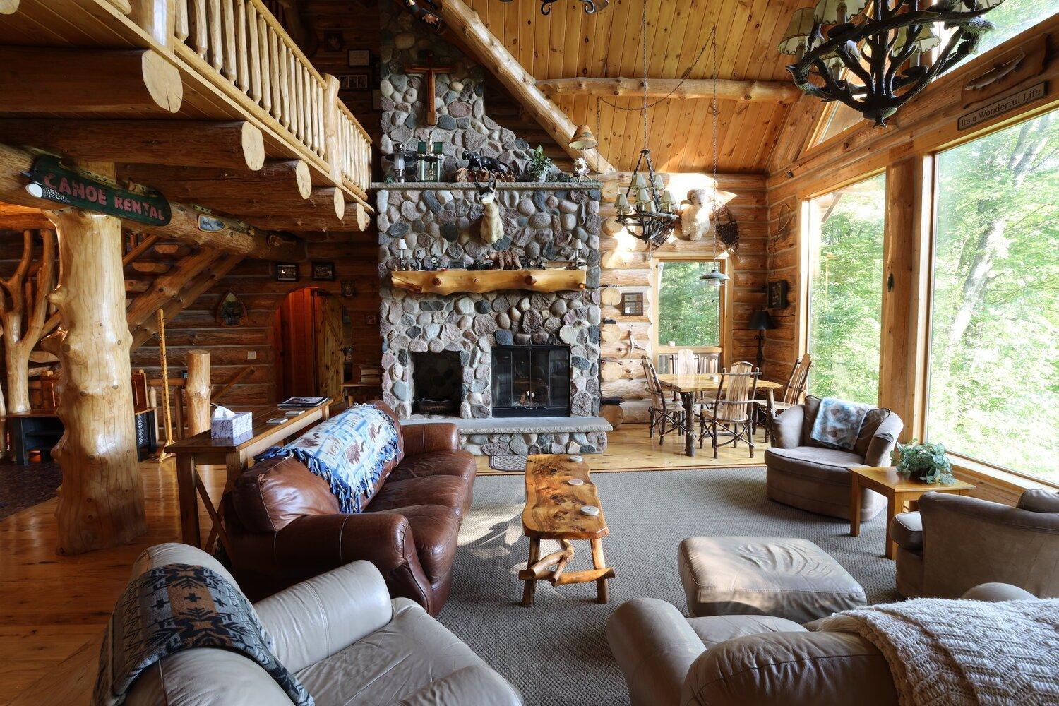 Great room at Edgetts Lodge with a stone fireplace and leather sofas